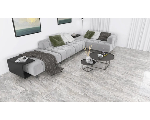 Vardagsrum med grå hörnsoffa, soffbord och klinkergolv i marmorlook