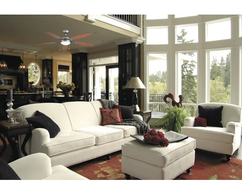 Vardagsrum med takfläkt, soffa, fåtölj och fönsterparti