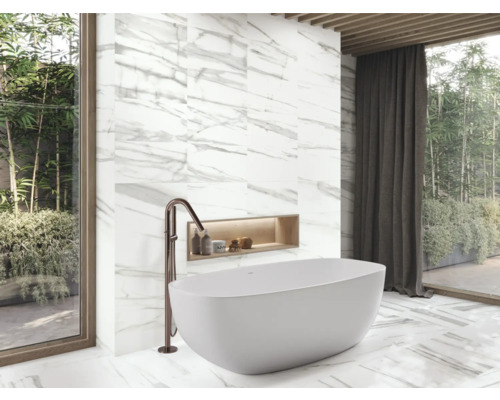 Modernt badrum med fristående badkar, armatur och marmorplattor.