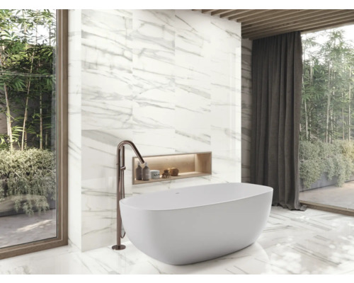 Badrum med badkar, armatur och väggplattor i marmorlook