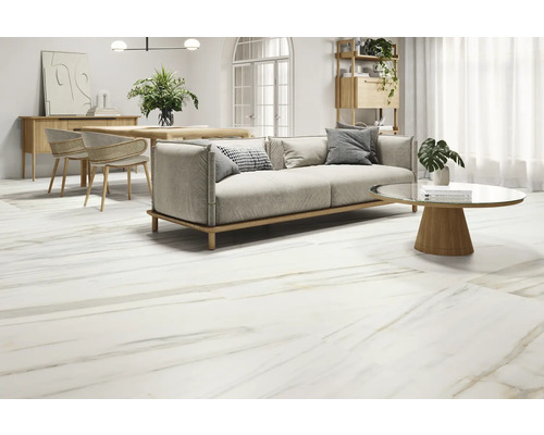Ljust vardagsrum med golvplattor i marmorlook, soffa, bord och stolar.
