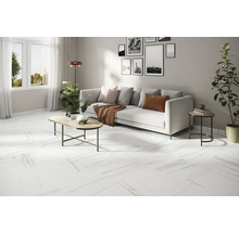 Ljust vardagsrum med vit soffa, soffbord och vitt golv med marmorlook.