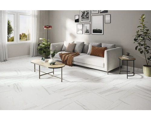 Ljust vardagsrum med vit soffa, soffbord och vitt golv med marmorlook.