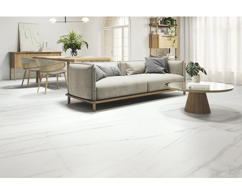 Vardagsrum med soffa, bord och golvplattor i marmorlook.