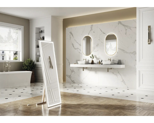 Ljust badrum med badkar, handfat, spegel och stående spegel med belysning