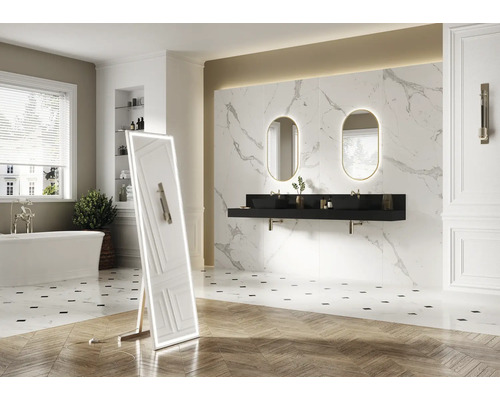 Badrum med badkar, tvättställ med två handfat och belyst spegel