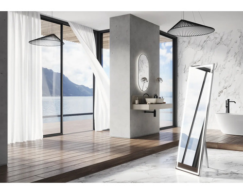 Badrum med fristående spegel, tvättställ, badkar och havsutsikt