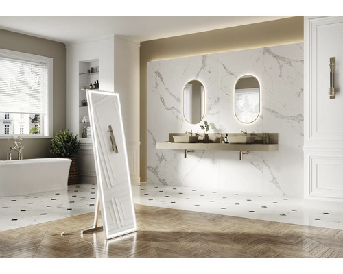 Ljust badrum med badkar, tvättställ med två handfat, speglar och stående helkroppsspegel