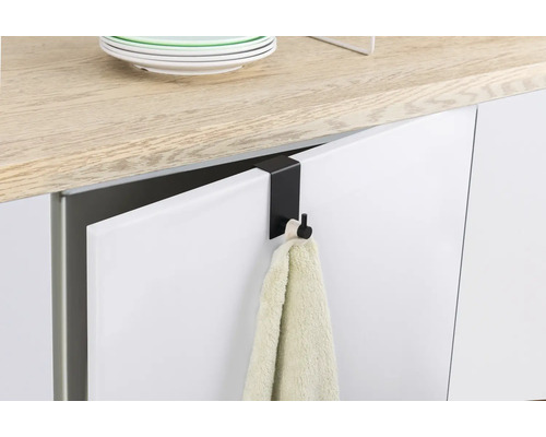 Svart dörrkrok med handduk på en köksdörr