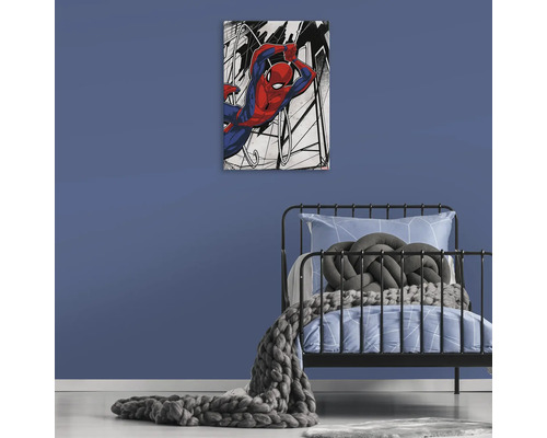 Dekorativ canvas med Spiderman-motiv ovanför en säng i ett barnrum