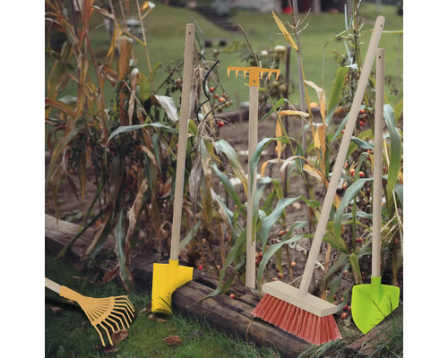 Trädgårdsscen med kratta, spade och kvast