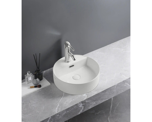 Rund tvättställsskål med blandare på en tvättställsskiva