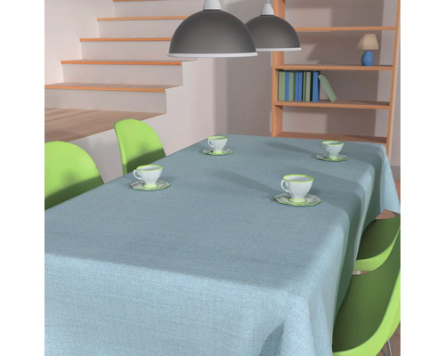 Matbord med duk, stolar och tekoppar i ett ljust rum