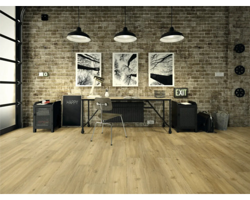 Kontor med skrivbord, stol, hyllor och trägolv framför en tegelvägg