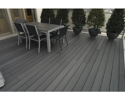 Terrass med trädäck, matbord och stolar utomhus.