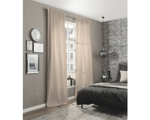 Modernt sovrum med säng och beiga gardiner framför fönstret