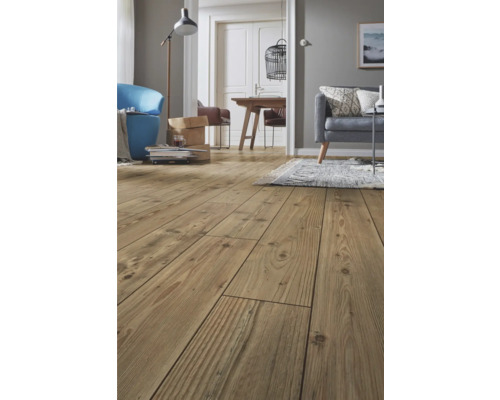 Vardagsrum med trägolv och olika möbler.