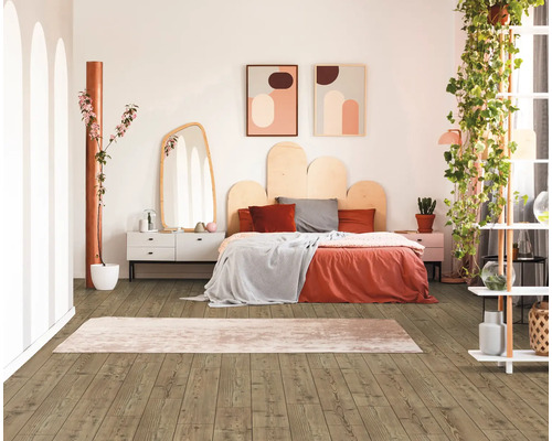 Ljust sovrum med trägolv, säng, byrå och dekoration