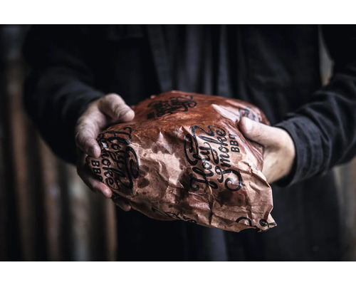 Person som håller en förpackad grillprodukt från Holy Smoke BBQ