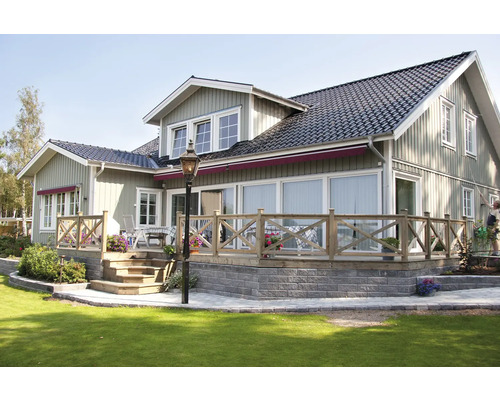 Exteriör av ett hus med träfasad, terrass och trädgård.