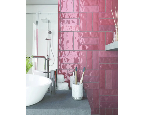 Badrum med handfat, dusch och väggplattor i tegelstenslook