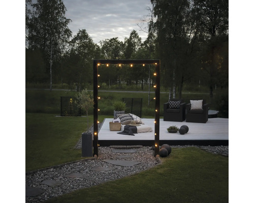 Trädgård med träterrass, sittplatser och ljusslinga för en mysig atmosfär