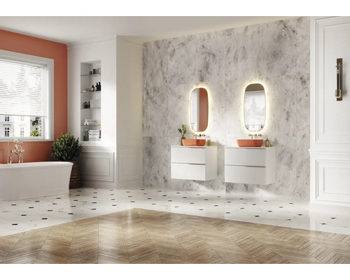 Ljust badrum med badkar, underskåp för tvättställ och belysta speglar