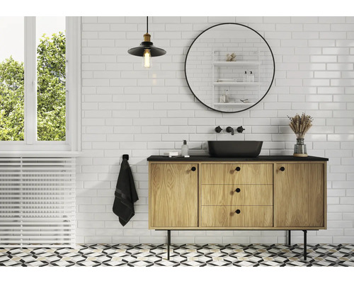 Ljust badrum med handfat, spegel och dekorativa element för en vänlig atmosfär.