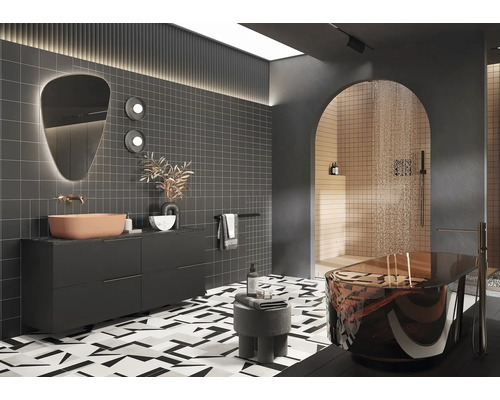 Modernt badrum med tvättställ, spegel, kakel och fristående badkar