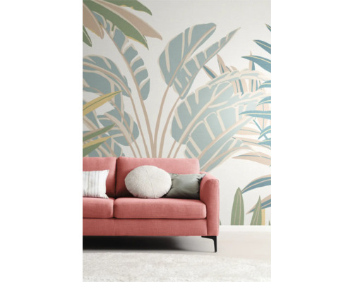 Vardagsrum med rosa soffa framför en vägg med växtmönster