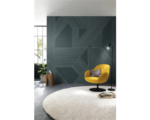 Modernt vardagsrum med mönstrad tapet, fåtölj, golvlampa och matta