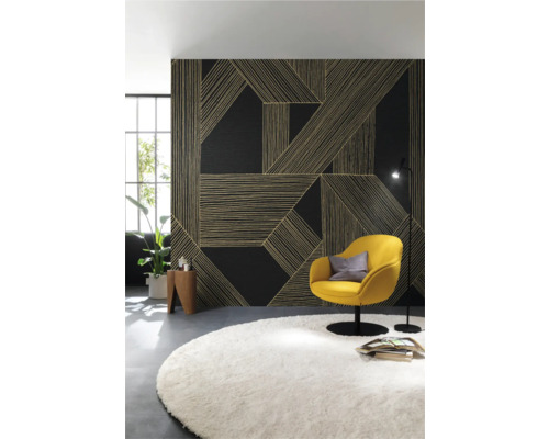 Vardagsrum med mönstrad väggbeklädnad, gul fåtölj och rund matta