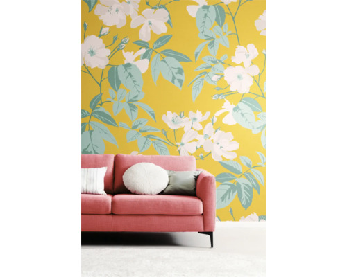 Rum med rosa soffa framför en vägg med blommönster
