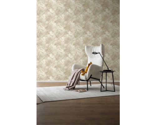 Vardagsrum med beige tapet med palmbladsmönster, fåtölj och sidobord.