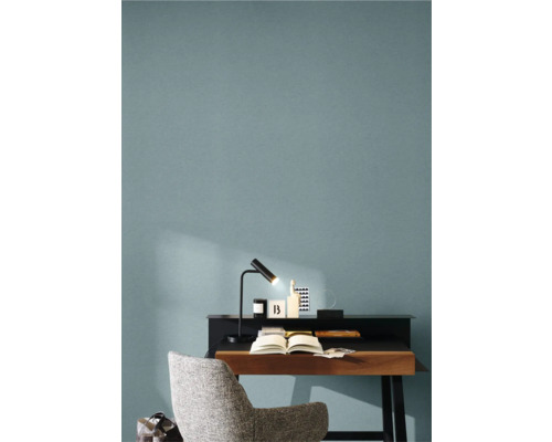 Arbetsrum med skrivbord, lampa, stol och öppen bok