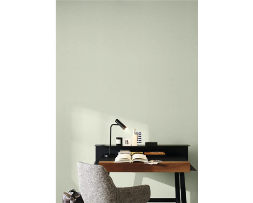 Arbetsrum med skrivbord, lampa och stol framför ljusgrön vägg