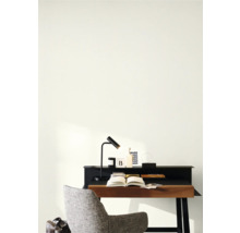 Ett skrivbord med en lampa, en stol och en öppen bok i ett arbetsrum.