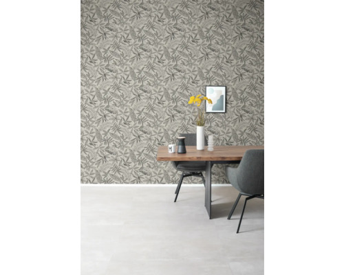 Matsal med matbord, stolar och mönstrad tapet med löv