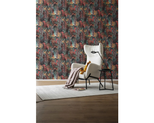 Vardagsrum med mönstrad tapet, fåtölj, golvlampa och matta för en mysig atmosfär