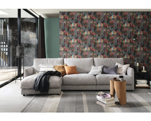 Vardagsrum med grå soffa, mönstrad tapet och dekorativa element för en mysig atmosfär.