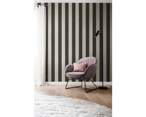 Inredningsidé med randig tapet, fåtölj och golvlampa för en stilfull atmosfär.