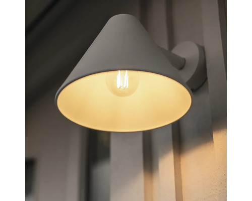 Grå vägglampa med konform och glödlampa tänd