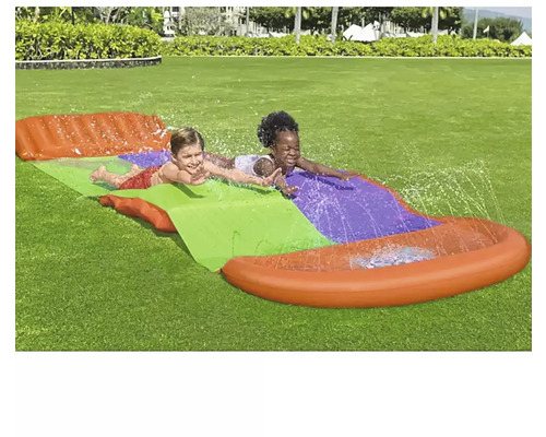 Två barn åker vattenrutschkana i trädgården.