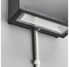 Närbild av en svart utomhuslampa med kabel på en vägg.