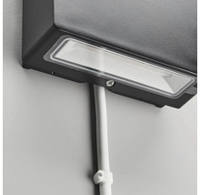 Närbild av en monterad utomhuslampa med kabelkanal på en vägg.