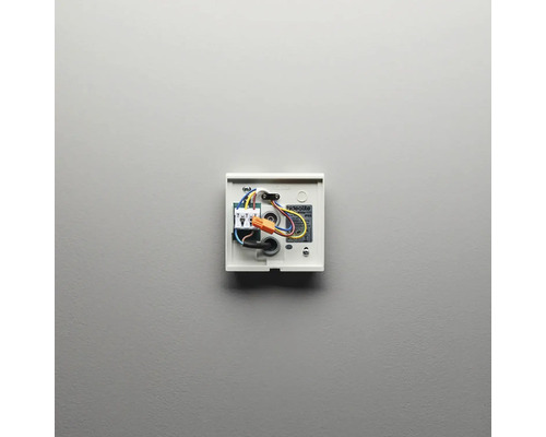 Öppen smart hemtermostat med kablar på väggen