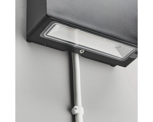 Detaljbild av en väggmonterad utomhuslampa med kabelkanal