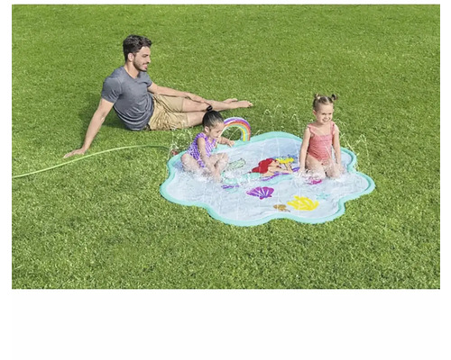 Utomhusscen med en man och två barn som leker på en vattensprutande lekmatta med havsmotiv i trädgården