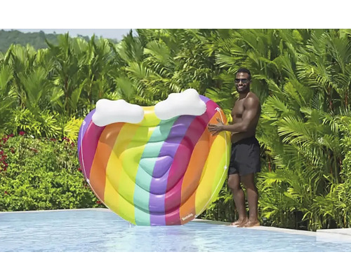 Uppblåsbar hjärtformad poolö med regnbågsfärger och molnapplikationer bredvid en pool