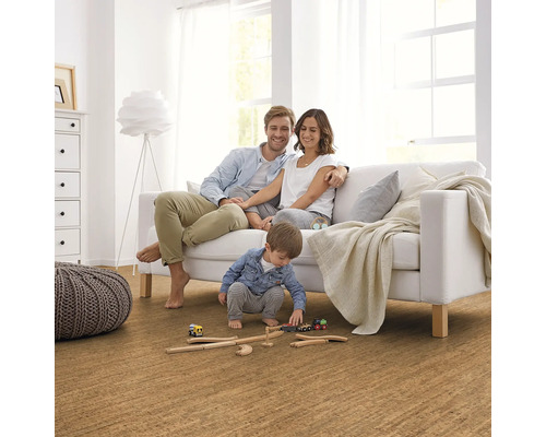 Familj kopplar av på en soffa i ett vardagsrum med korkgolv.